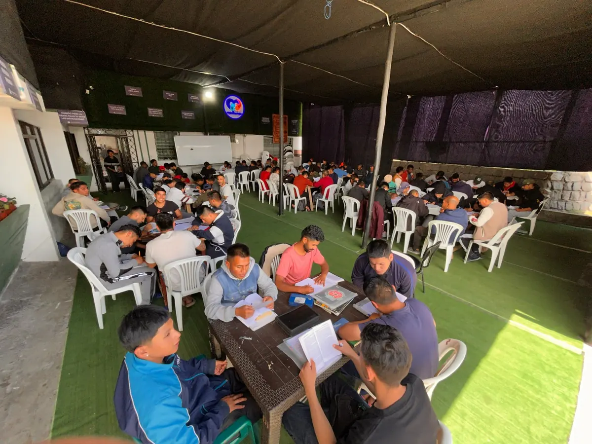 Residentes en clase grupal bajo la carpa de la casa