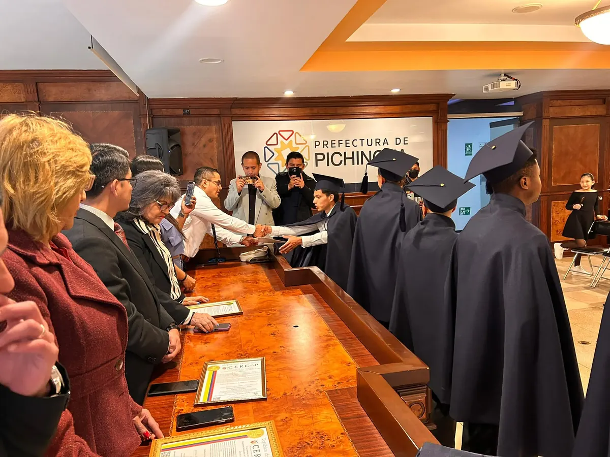 Residentes recibiendo certificados en una ceremonia en la Prefectura de Pichincha